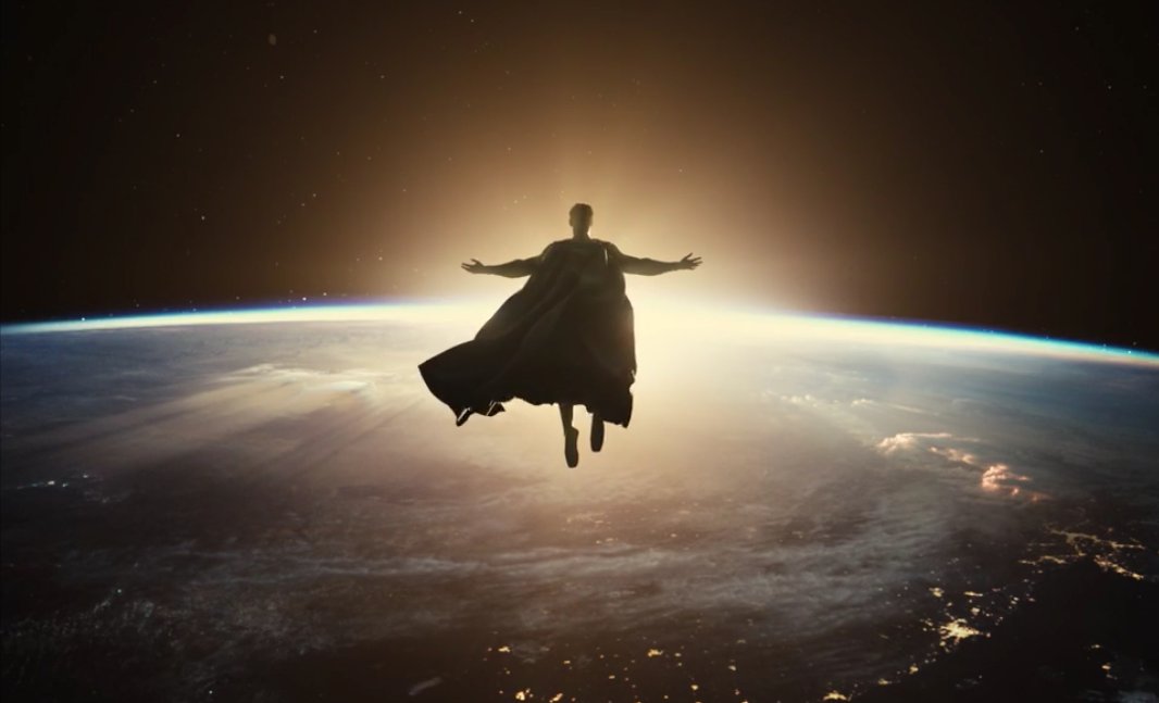 Superman con brazos abiertos en pose de crucifixión sobre la Tierra iluminada
